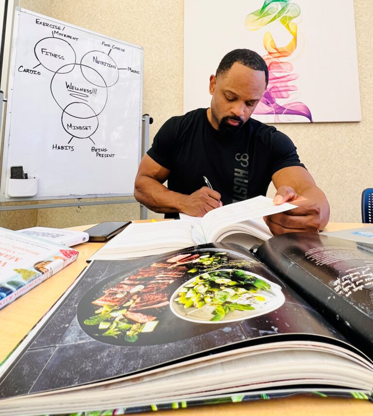 Anthony studying and taking notes from text.